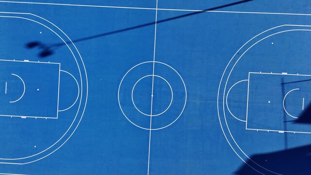 Top view of blue outdoor basketball court with white lines