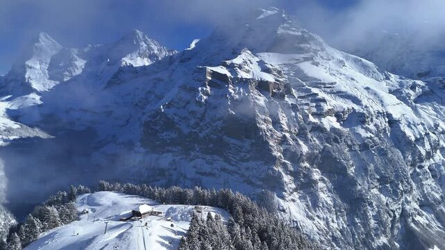 Drone video of M&auml;nnlichen in winter, featuring snow-covered ski slopes, alpine terrain, and scenic mountain views in Switzerland.