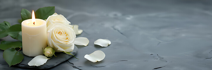 White candle with a rose and flower petals on grey stone panoramic background with copy space, funeral services web banner