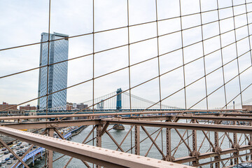 Naklejka premium The scenic views of the Brooklyn Bridge, which is a cable-stayed suspension bridge in New York City, spanning the East River between the boroughs of Manhattan and Brooklyn.