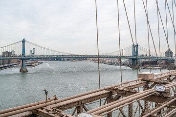 Obraz premium The scenic views of the Brooklyn Bridge, which is a cable-stayed suspension bridge in New York City, spanning the East River between the boroughs of Manhattan and Brooklyn.