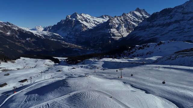 Drone video of M&auml;nnlichen in winter, featuring snow-covered ski slopes, alpine terrain, and scenic mountain views in Switzerland.