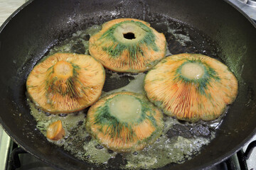 Frying saffron milk cap mushrooms in a pan with butter