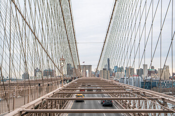 Obraz premium Brooklyn Bridge, NYC, US - January 23, 2026: people are visiting the Brooklyn Bridge, which is a cable-stayed suspension bridge in New York City, US.