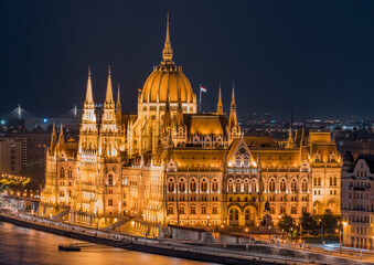 Obraz premium Blue hour view of the Hungarian Parliament illuminated along the Danube River. A majestic European cityscape showcasing Budapest iconic architecture at twilight