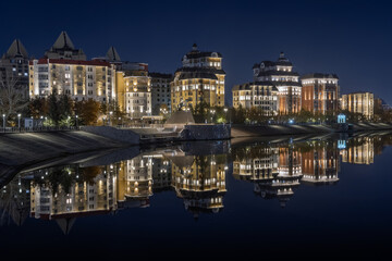  Residential buildings with night illumination and embankment are reflected in the Ishim (Esil) river in Astana, the capital of Kazakhstan