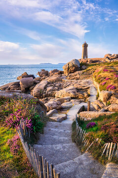 Phare de Mean Ruz on the Pink Granite Coast with rocky shoreline and coastal path in Ploumanach, Brittany, France