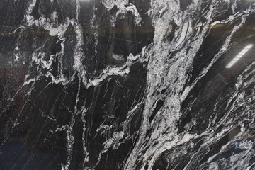 Fototapeta premium Copacabana marble from Brazil featuring contrasting black and white patterns resembling water flow or natural abstract paintings.