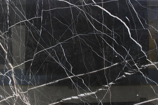 Nero Marquina marble with a deep black background and white veins that cross each other randomly and sharply.
