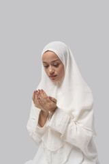 Downward focused woman with cupped hands, white headscarf and soft expression, neutral studio backdrop, manicure detail and quiet