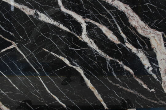 Detail of Portoro black marble vein pattern with thick white and cream lines providing a classic and artistic nuance.