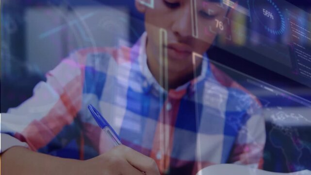 Male teenager taking notes in notebook at desk, pen touching page initiating tech charts overlaying