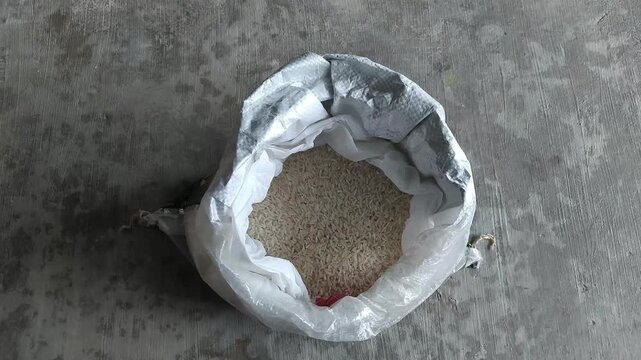 Paper with zakat message placed on a sack of rice. Representation of almsgiving, Ramadan donation, and caring for those in need.