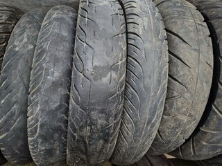 Obraz premium Close up of worn motorcycle tires showing damaged tread texture and rubber surface detail