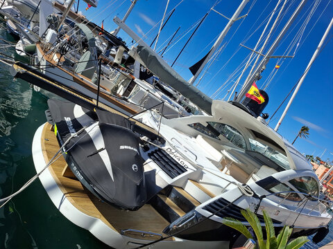 DENIA, SPAIN - February 8, 2026. Luxury Pershing yacht with Sea Doo jet ski on swimming platform in harbor with Spanish flag flying