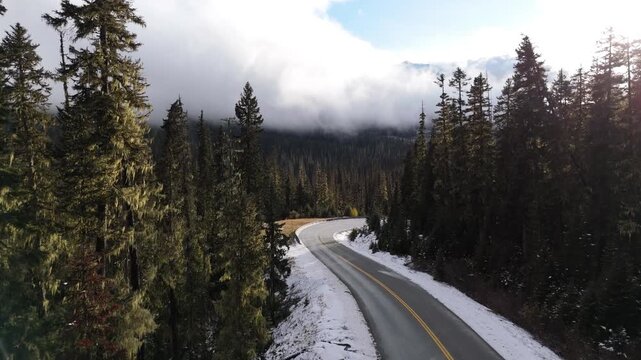 Scenic Winding Mountain Road Through Snow-Dusted Forest in Beautiful British Columbia, Canada