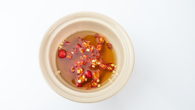 Red chili peppers fish sauce bowl on white background.
Dipping Prik Nam Pla traditional thai restaurant.
top view