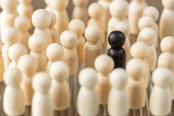 A single black figure among white ones. Social concept. Black sheep, a person who stands out in a crowd, doesn't fit in with the rest. pushed out of the social circle. © Rochu_2008