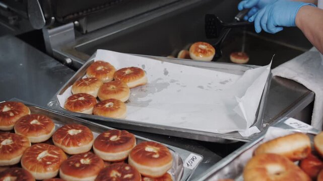 Freshly fried belyashi being made in a commercial kitchen.
