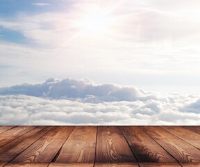 Empty perspective wooden plank floor with the   nature of the sky, fluffy clouds, and morning sunlight background.Use as products display montage.