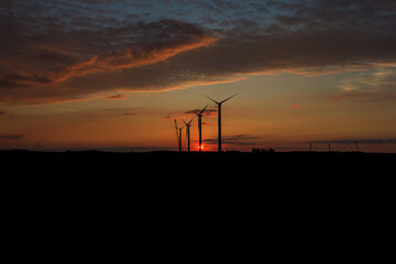wind turbines at sunset with crane