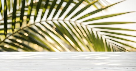 White wooden table with blurred palm leaves background © Natalia