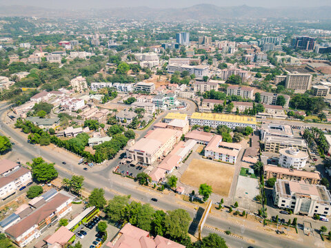 Aerial view of a vibrant city unfolds with buildings nestled among lush greenery, roads crisscrossing, creating a tapestry of urban life, Abuja, Federal Capital Territory, Nigeria.