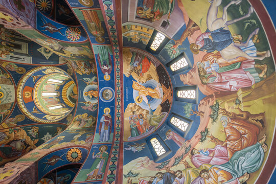 View of vibrant frescoes dance across a domed ceiling, depicting biblical scenes in rich detail, illuminating the sacred space, Ljubljana, Slovenia.