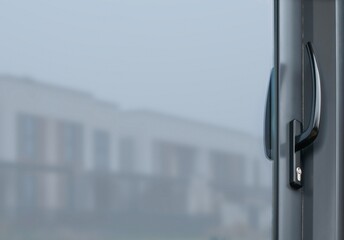 The handle of the plastic sliding door is dark in color