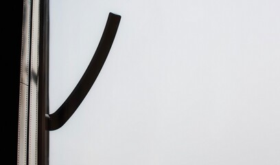 The handle of the plastic sliding door is dark in color