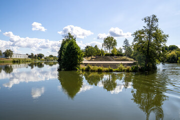 Fototapeta premium Boat tour on the river near Erba Island (Erbainsel) in Bamberg, Bavaria, Germany, scenic waterway surrounded by nature, green riverside landscape and relaxing European travel destination.