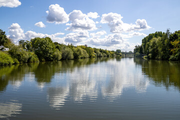 Obraz premium Boat tour on the river near Erba Island (Erbainsel) in Bamberg, Bavaria, Germany, scenic waterway surrounded by nature, green riverside landscape and relaxing European travel destination.