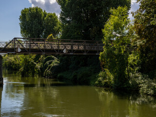 Boat tour on the river near Erba Island (Erbainsel) in Bamberg, Bavaria, Germany, scenic waterway surrounded by nature, green riverside landscape and relaxing European travel destination.