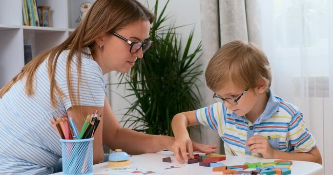 Woman and boy engaged in creative activity at table in bright home interior