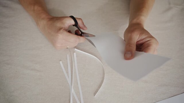 Close detail shot of scissors cutting paper. Camera highlights sharp blades, precise motion and focused manual work. High quality 4k footage