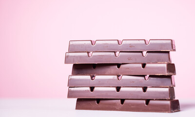 Delicious dark chocolate on a pink background