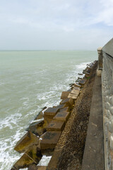 Fototapeta premium Cadiz Spain Sea Defense Breakwater with Concrete Armor Blocks along Atlantic Coastline Historic Stone Wall and Coastal Engineering in Andalusia under Overcast Sky