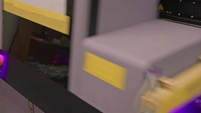 4K footage of a UV flatbed printer simultaneously printing an image on ten mobile phone case. Modern industrial digital printing process for custom phone accessory production.