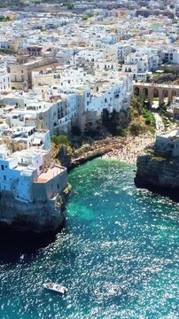 Coastal cove with white houses of Polignano a Mare above turquoise sea, Italy