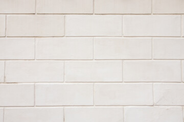 White ceramic tile wall with glossy finish, featuring rectangular tiles arranged in a staggered pattern, suitable for interior design and home improvement projects