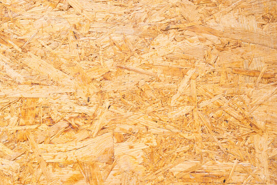 Close-up view of oriented strand board (OSB) surface showcasing natural wood texture and color variations, ideal for construction and interior design applications