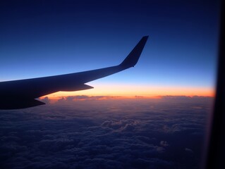 Fototapeta premium 夕焼けに染まる雲海の上を進む飛行機の翼から眺める静かな空の旅路