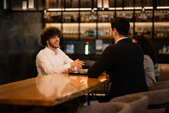 Business partners having informal meeting and discussion in bar