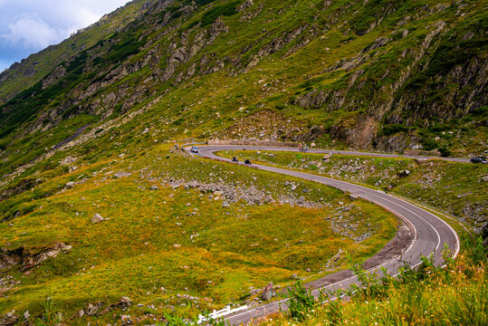 Mountain switchback road with vehicles. Vehicles drive along a high mountain switchback on the Transfagarasan route