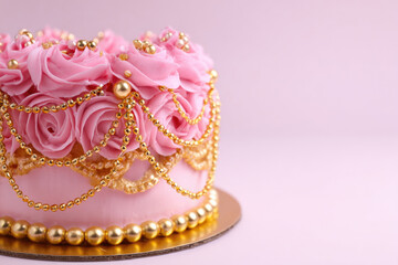 Pink cake with cream roses and gold. Space for text.