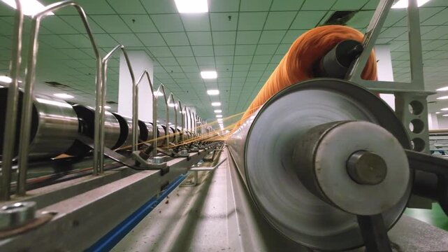 Textile factory spinning machines operating at high speed in production workshop