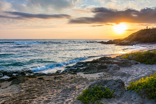 landscape of black sea sandy beach at sunrise. golden sand and rocks on the coast of bulgaria. beautiful view with sun above horizon. european summer vacation season and leisure concept
