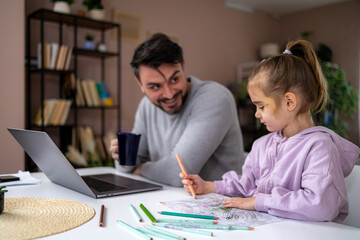 Naklejka premium Father and daughter color together at home during afternoon while laptop is open