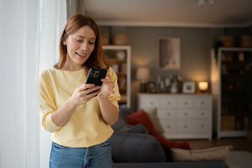 Woman smiling using smartphone for social media at home