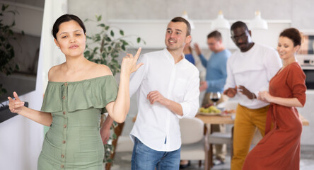 Obraz premium Positive friendly pairs in their middle years dancing actively in warm home environment